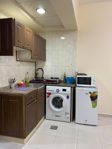 a kitchen with a stove and a washing machine at Entire Studio Flat in Sharjah. in Sharjah