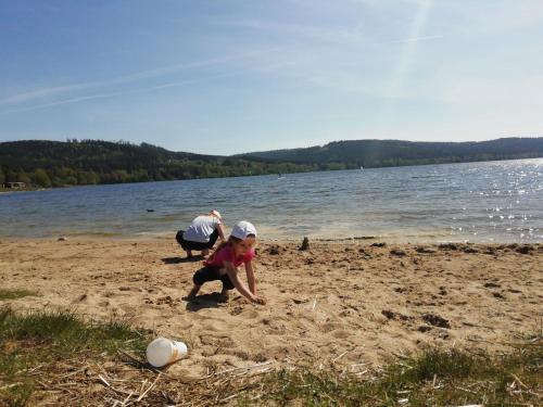 a little girl playing in the sand on the beach at Lipno Club in Frymburk