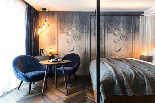 a bedroom with a bed and two chairs and a table at SILENA, your soulful hotel - adults only in Valles