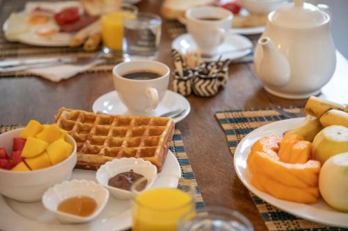 a table with plates of breakfast foods and cups of coffee at Shoki Shoki Hotel Stone Town in Zanzibar City