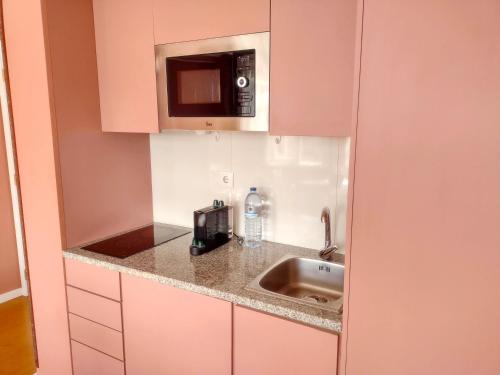 a kitchen with a sink and a microwave at Oporto Center Clean & Cozy Apt 3 in Porto