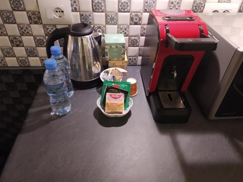 a counter with a coffee maker and a bottle of water at Olive Tree in Tirana