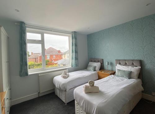 伯恩茅斯的住宿－Charming 3 bed house and garden, pet friendly，一间卧室设有两张床和窗户。