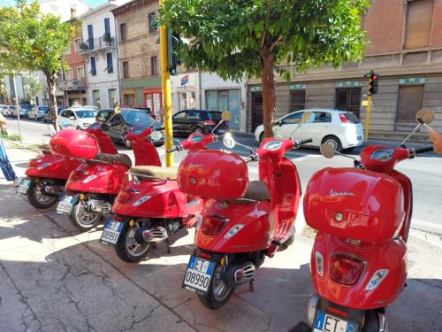 a row of red scooters parked on a street at Casale di Maro in Monte Giberto