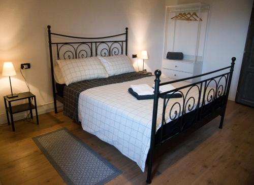 1 dormitorio con 1 cama con marco negro y sábanas blancas en Casale di Maro, en Monte Giberto