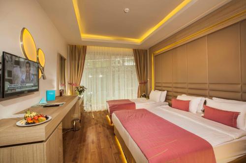 a hotel room with two beds and a desk at Orka Lotus Beach in Marmaris