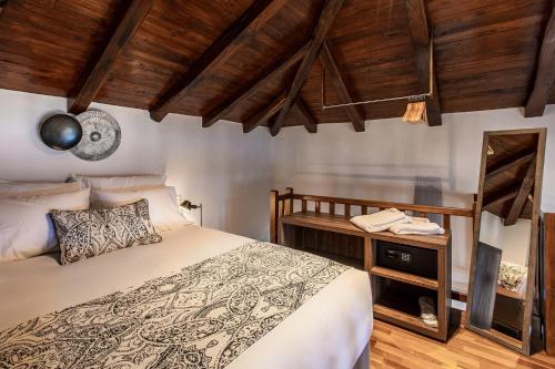 1 dormitorio con cama y techo de madera en Tilia Resort, en Mouresi