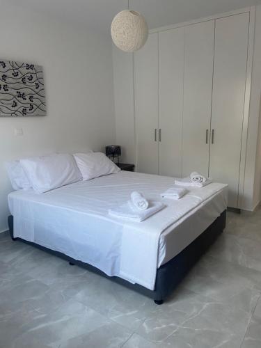 um quarto com uma cama branca e toalhas em Player Sea View apartment em Pafos