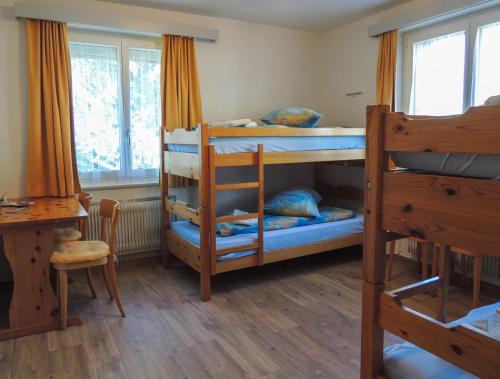 Zimmer mit 2 Etagenbetten und einem Schreibtisch in der Unterkunft B&B Haus Schönstatt contactless- Check-In in Brig
