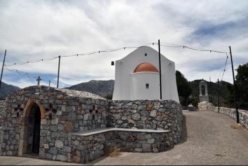 a stone wall with a small building on it at Traditional Residence with terrace in Latsídha
