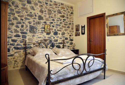 a bed in a room with a stone wall at Traditional Residence with terrace in Latsídha