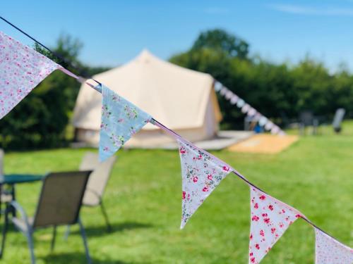 a string of flags with a table and chairs in a field at Valley Farm Bells in Oxford