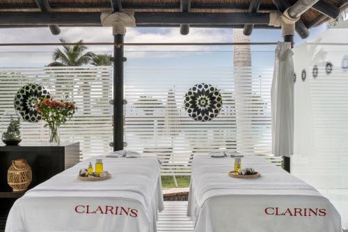 two white tables with white chairs with flowers on them at Gran Melia Palacio de Isora Resort & Spa in Alcalá