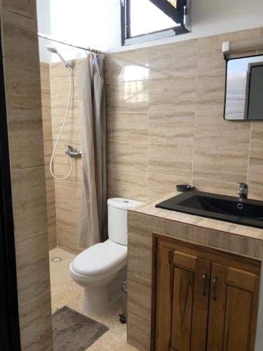 La salle de bains est pourvue de toilettes et d'un lavabo. dans l'établissement La Maison Aziz - Somone / Sénégal, à La Somone