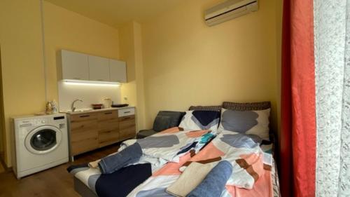 a bedroom with a bed and a washing machine at AFRODITA 108 Studio Sunny Beach in Sunny Beach