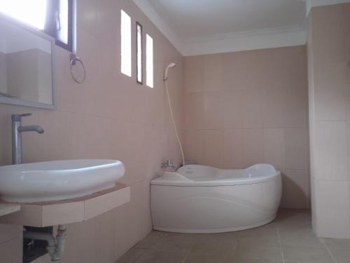 a white bathroom with a sink and a toilet at family house hotel kuta in Kuta Lombok