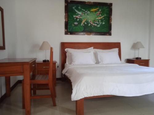 a bedroom with a bed and a desk and a bed sidx sidx sidx at family house hotel kuta in Kuta Lombok