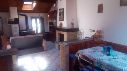 a living room with a fireplace and a dining room at Casa del Rustico, Indipendente vista Sacra con dipinto in Caprie