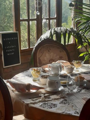 a table with a tea set on top of it at Cabañas Puente Negro in Puente Negro