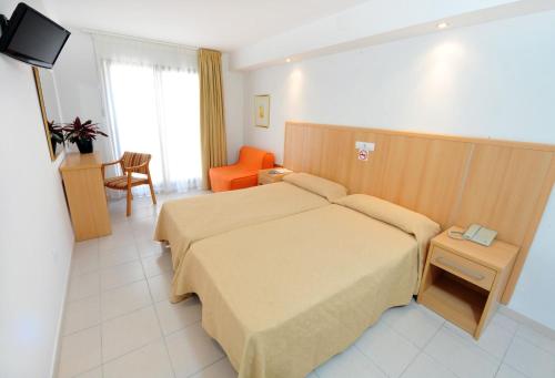 a hotel room with a bed and a chair at Hotel Montemar in Benidorm