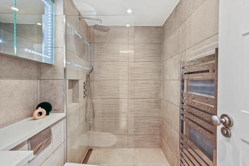 a bathroom with a shower with a glass door at Cleveland Street by Q Apartments in London
