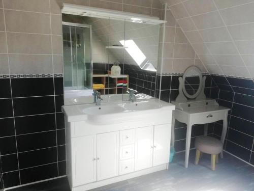 a bathroom with a white sink and a mirror at Villa de 5 chambres avec piscine privee jacuzzi et jardin clos a Saint Clair d'Arcey in Bernay