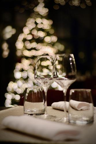 two wine glasses sitting on a table with a christmas tree at Château Origny - Moulins in Neuvy
