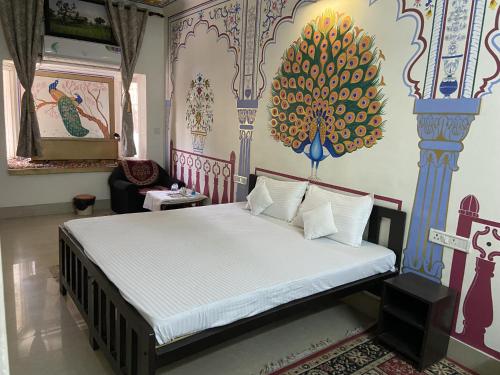 une chambre avec un lit avec un tableau sur le mur dans l'établissement Golden Peacock Heritage Home Stay, à Jaipur