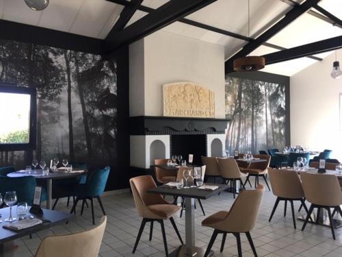 une salle à manger avec des tables, des chaises et une cheminée dans l'établissement LOGIS Hôtel LES 3 MARCHANDS, à Bressuire