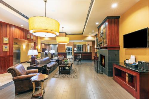 a living room with leather furniture and a fireplace at Holiday Inn Ardmore by IHG in Ardmore