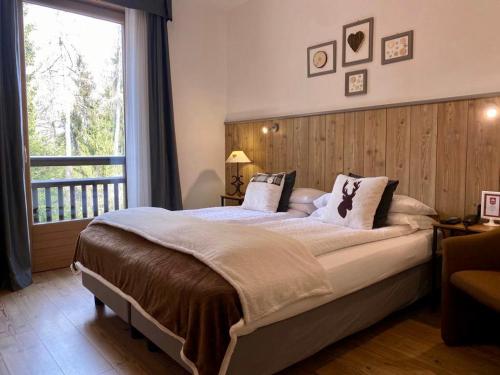 a bedroom with a large bed with a large window at Hotel Derby in Folgarida
