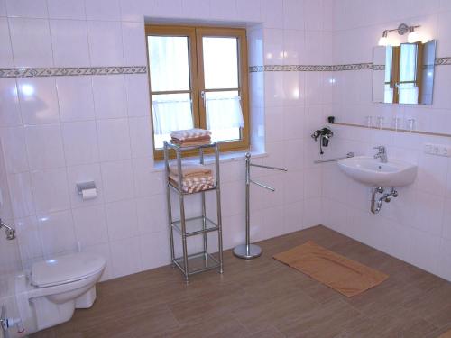 a bathroom with a toilet and a sink at Gästehaus Weissenbauer in Lenggries