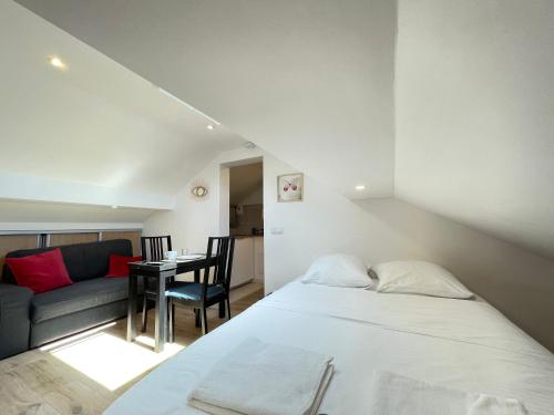 sypialnia z łóżkiem, kanapą i stołem w obiekcie Appart'Village Jouy les Metz w mieście Jouy-en-Josas