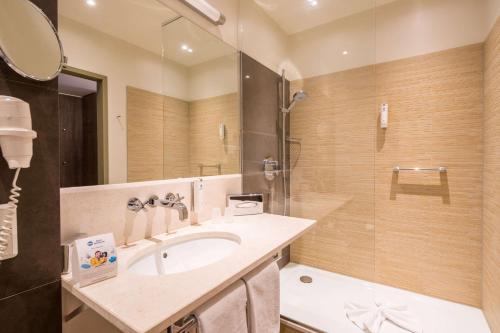 a bathroom with a sink and a shower at Best Western Hotel Schlossmühle Quedlinburg in Quedlinburg