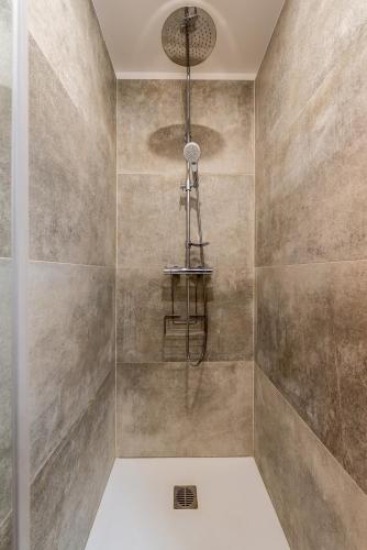 La salle de bains est pourvue d'une douche et d'un éclairage. dans l'établissement DOWNTOWN COCOON - CENTRE VILLE - WiFi - NETFLIX, à Amiens