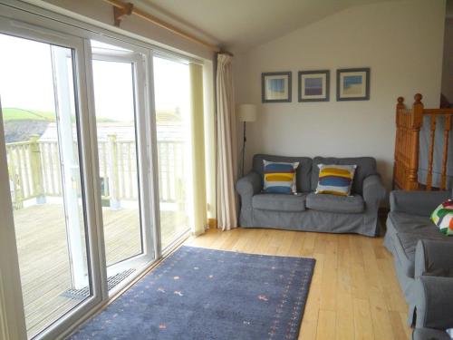 a living room with a couch and a sliding glass door at Bay View, Port Isaac in Port Isaac