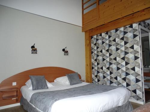 Ένα ή περισσότερα κρεβάτια σε δωμάτιο στο LOGIS Hôtel LES 3 MARCHANDS
