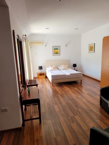 a bedroom with a bed and a wooden floor at Pension Edelweiss in Eforie Sud