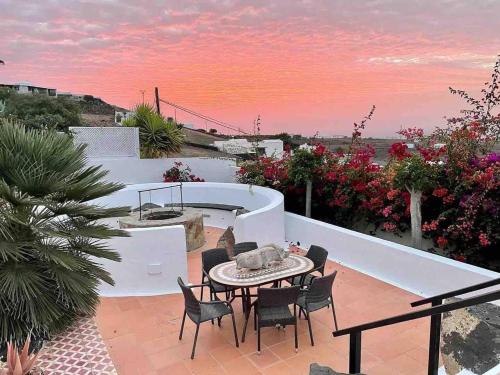 a patio with a table and chairs and a sunset at Villa Papaz - cosy spacious sea view pool in Conil