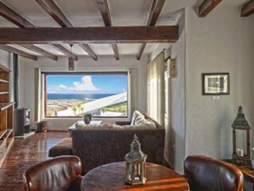 a man sitting on a couch in a living room at Villa Papaz - cosy spacious sea view pool in Conil