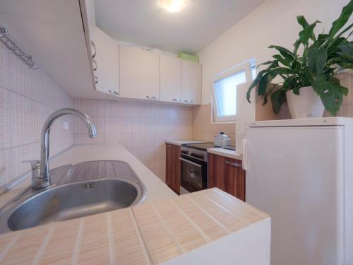 a kitchen with a sink and a white refrigerator at Apartments Branko in Budva