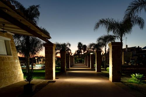 a pathway with palm trees and a building at Tenuta De Masi by LoveSud in Corsano
