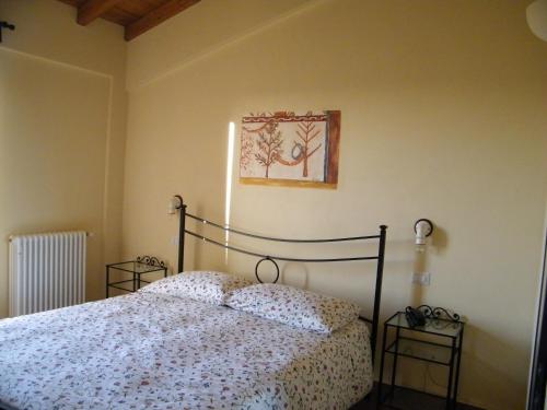 a bedroom with a bed and a picture on the wall at Agriturismo Sant' Antonio di Saturnia in Manciano