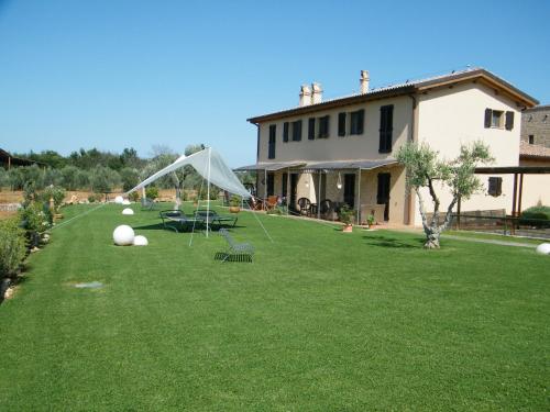 a lawn with a tent in the yard of a house at Agriturismo Sant' Antonio di Saturnia in Manciano