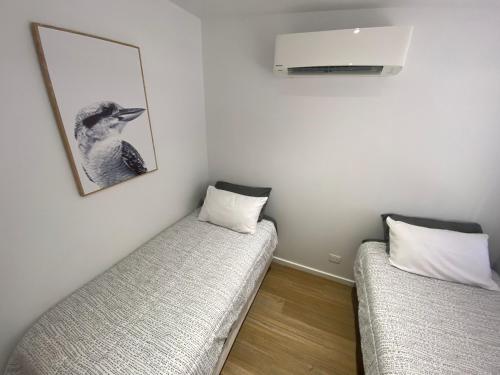 duas camas num quarto com uma fotografia na parede em Holly Place em Coober Pedy