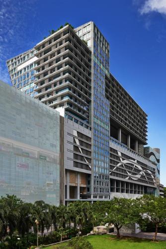 a tall glass building with trees in front of it at JEN Singapore Orchardgateway by Shangri-La in Singapore