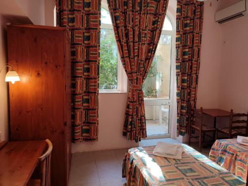 a room with a bed and a window with curtains at SC Club Village in Pembroke 