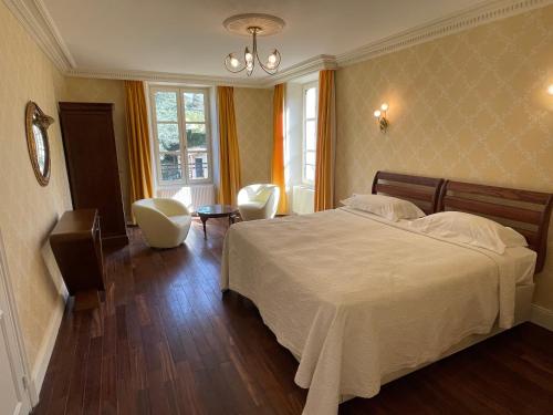 een slaapkamer met een bed en een tafel en stoelen bij the Parc Place in Sarlat-la-Canéda