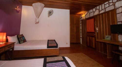 a small room with a bed and a tv at TARA LODGE Haven of peace in Kep