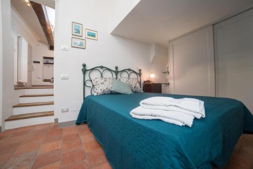 a bedroom with a blue bed with towels on it at Le Case di Angelina - Langhe Loft & Suites in Farigliano